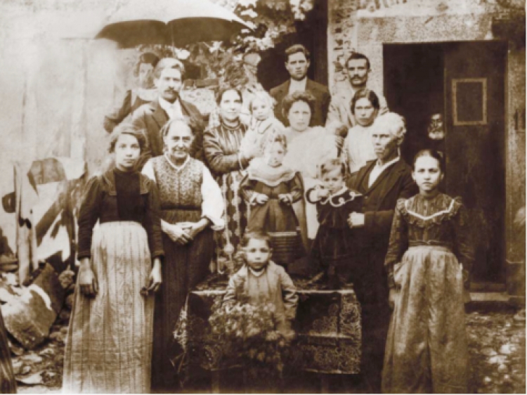 La famiglia Timpano (“Fatunedha”) nel quartiere “Zzàccanu&quot;, in posa di fronte alla casa di mastro Bruno, che si vede seminascosto dalla porta (Stampa fotografica del 1965 da un originale perduto, collezione privata)